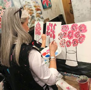 a woman painting on canvas