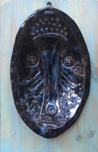 a black ceramic object with a pattern on it